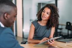 Une femme et un homme en train de discuter autour d'une tablette