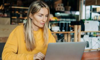 femme devant son ordinateur calculant la révision du loyer de son bail commercial