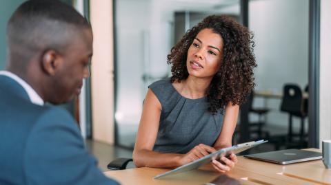 Une femme et un homme en train de discuter autour d'une tablette